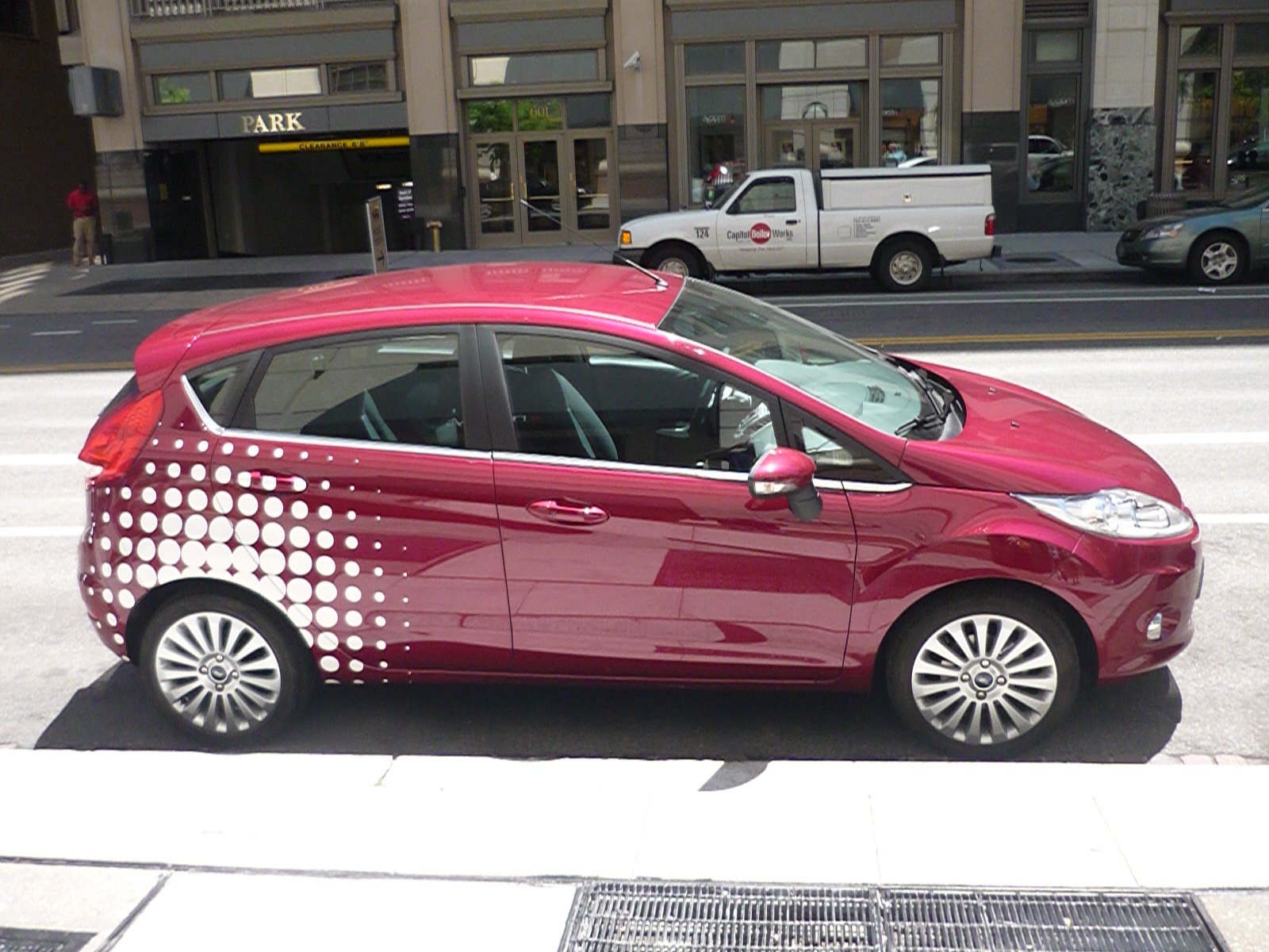 a car painted red with designs is parked on the side of a street