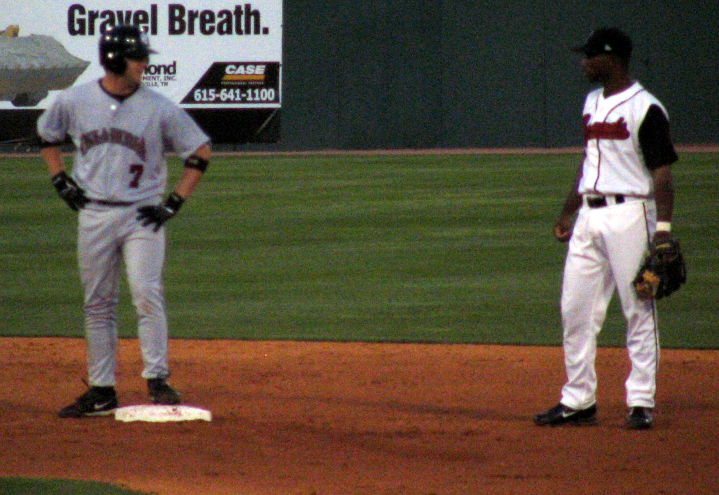 the two baseball players are having a conversation