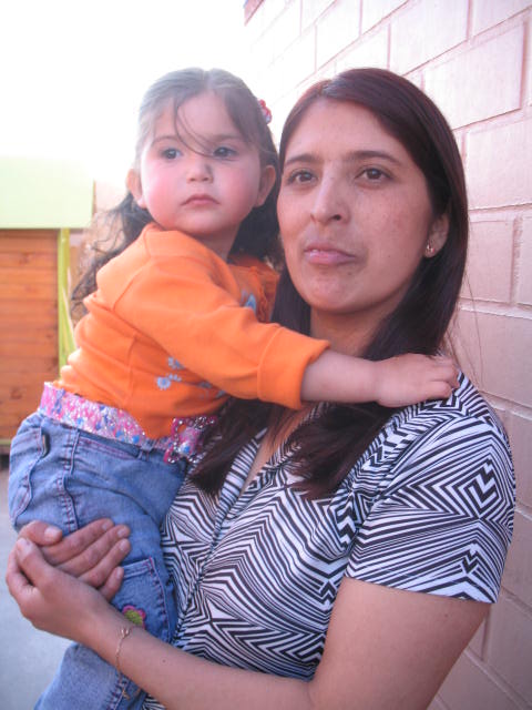 a woman holding a small child up against a wall