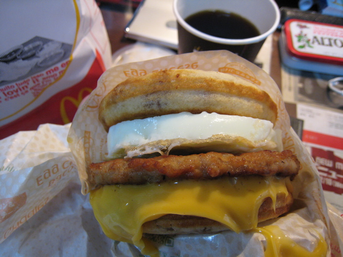 a sandwich with cheese, meat and bread sitting on top of a table