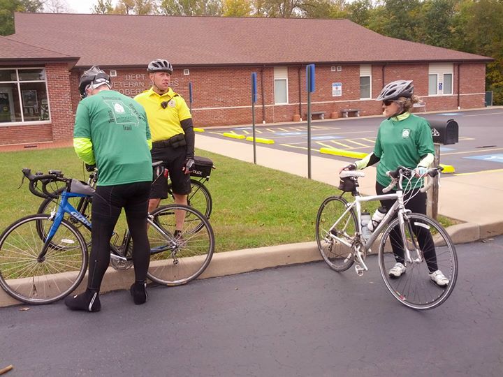 two bicyclists are stopped in the street with their bicycles