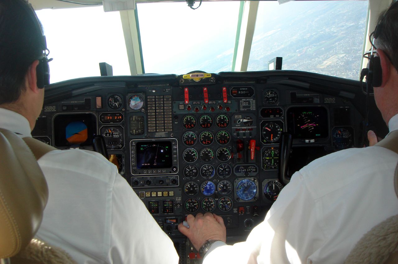two pilots sitting in the front seat of an airplane