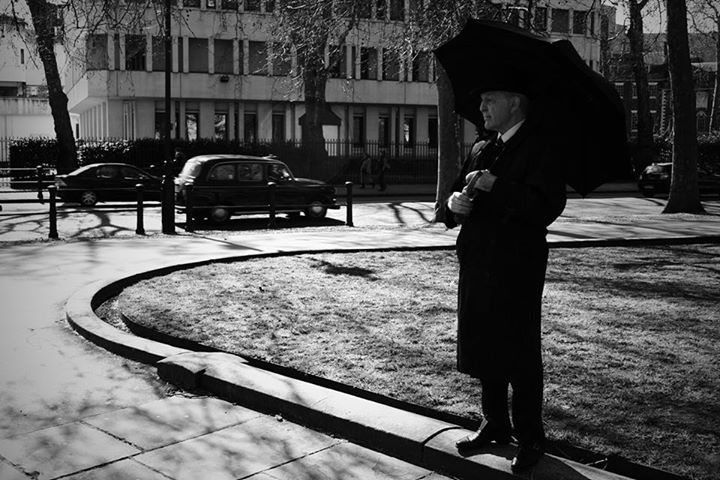 a man standing on the grass near a road