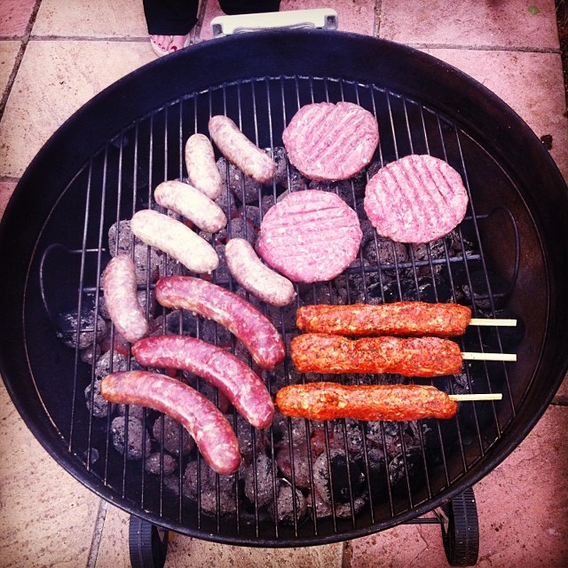 burgers and  dogs being cooked on the grill