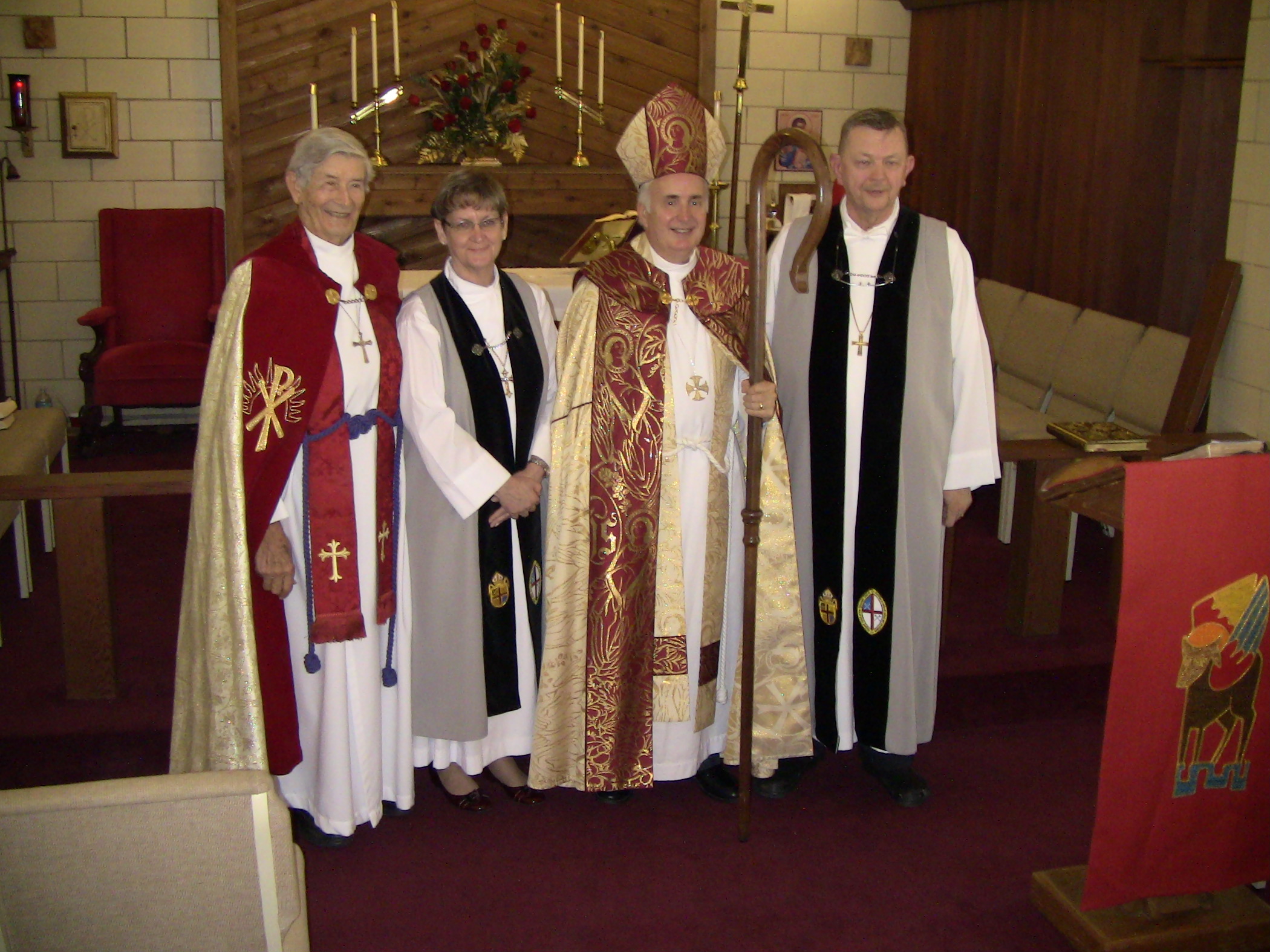 a priest and three men are standing together
