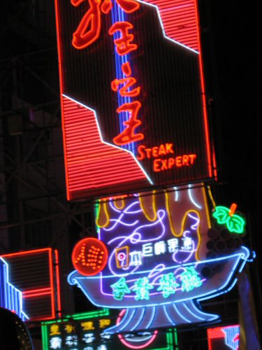 neon signs with various languages are lit up