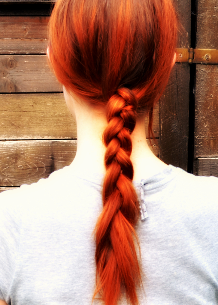 a redhead female with orange hair is seen from behind