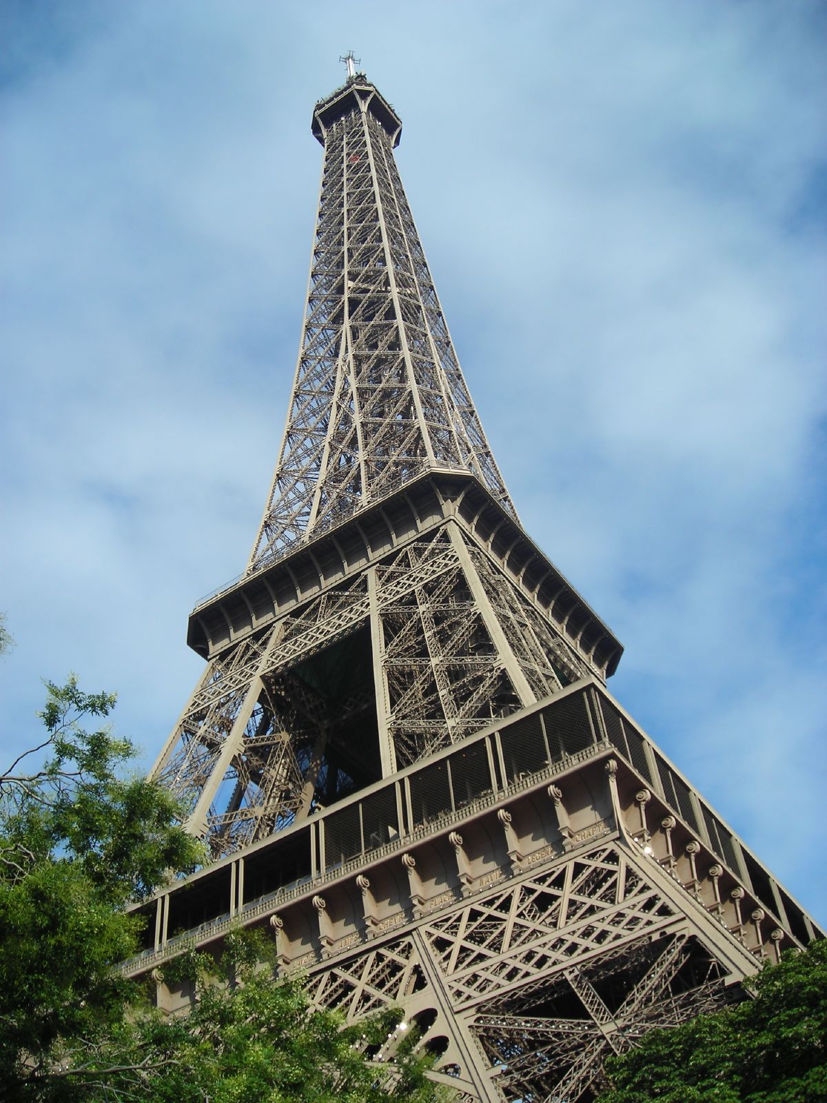 the eiffel tower against a bright blue sky with clouds