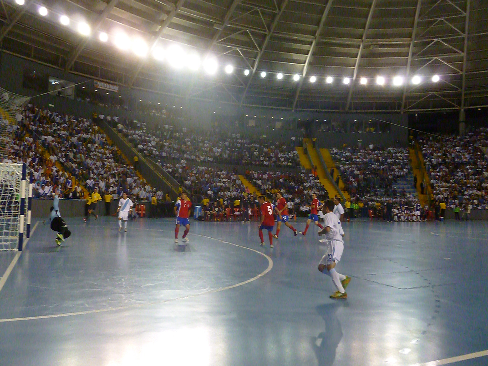 several men are playing soccer on an indoor arena