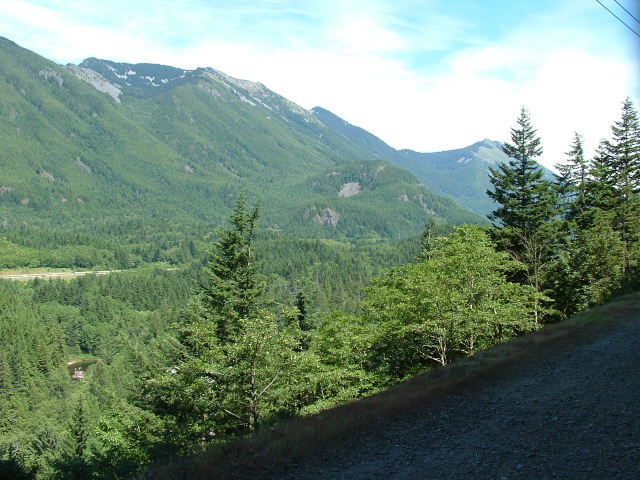 a road passing between some trees and hills