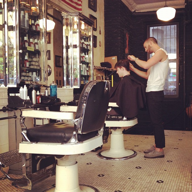 the barber is  the man's hair in a salon