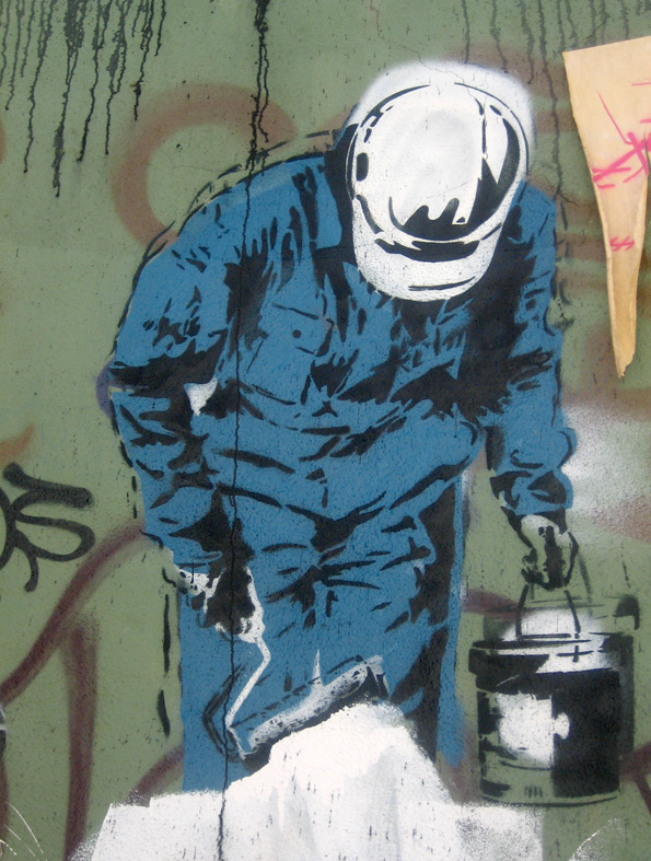 a man in blue jumpsuit, paint can and a white hat