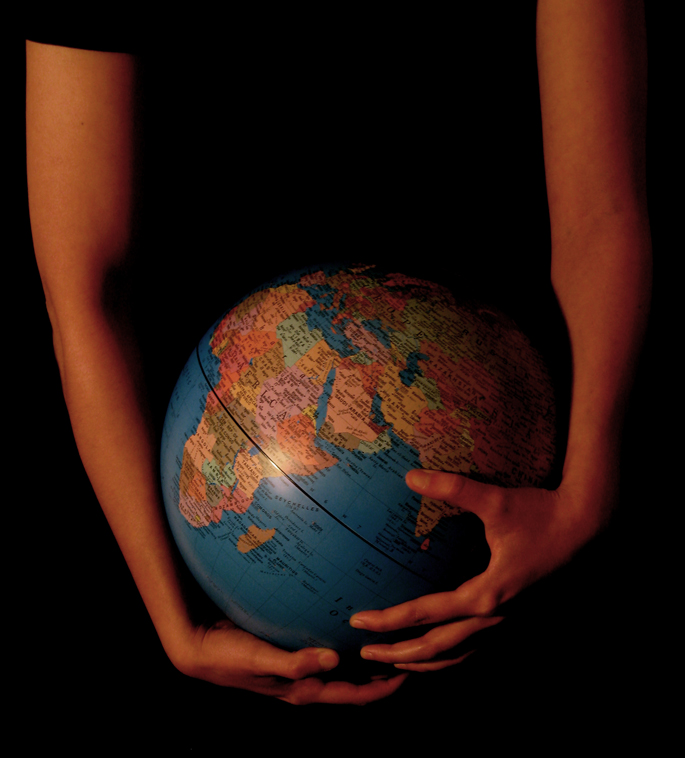 hands holding a globe in the dark