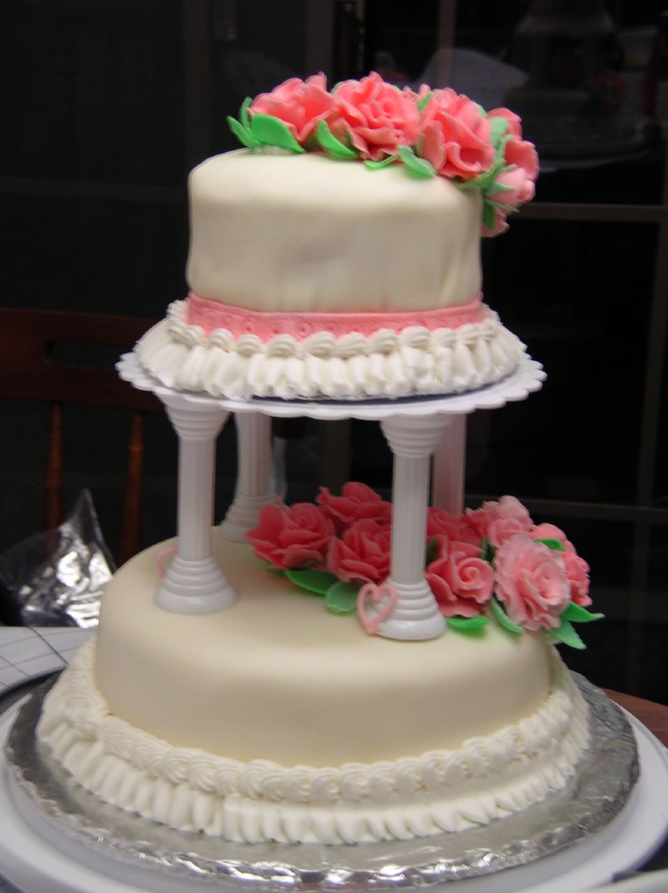 a three tiered cake with pink roses on it