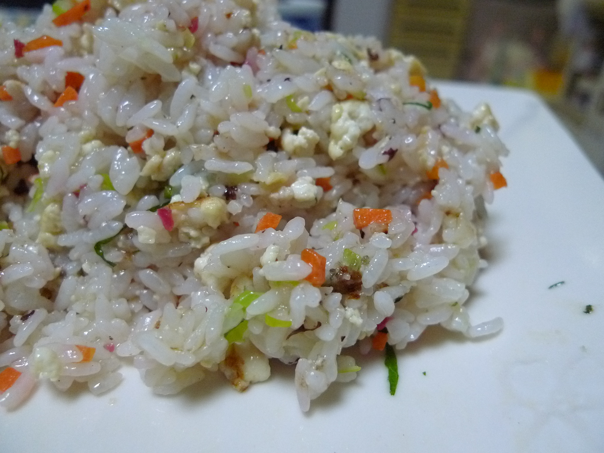rice with carrots and seasoning is sitting on a white plate