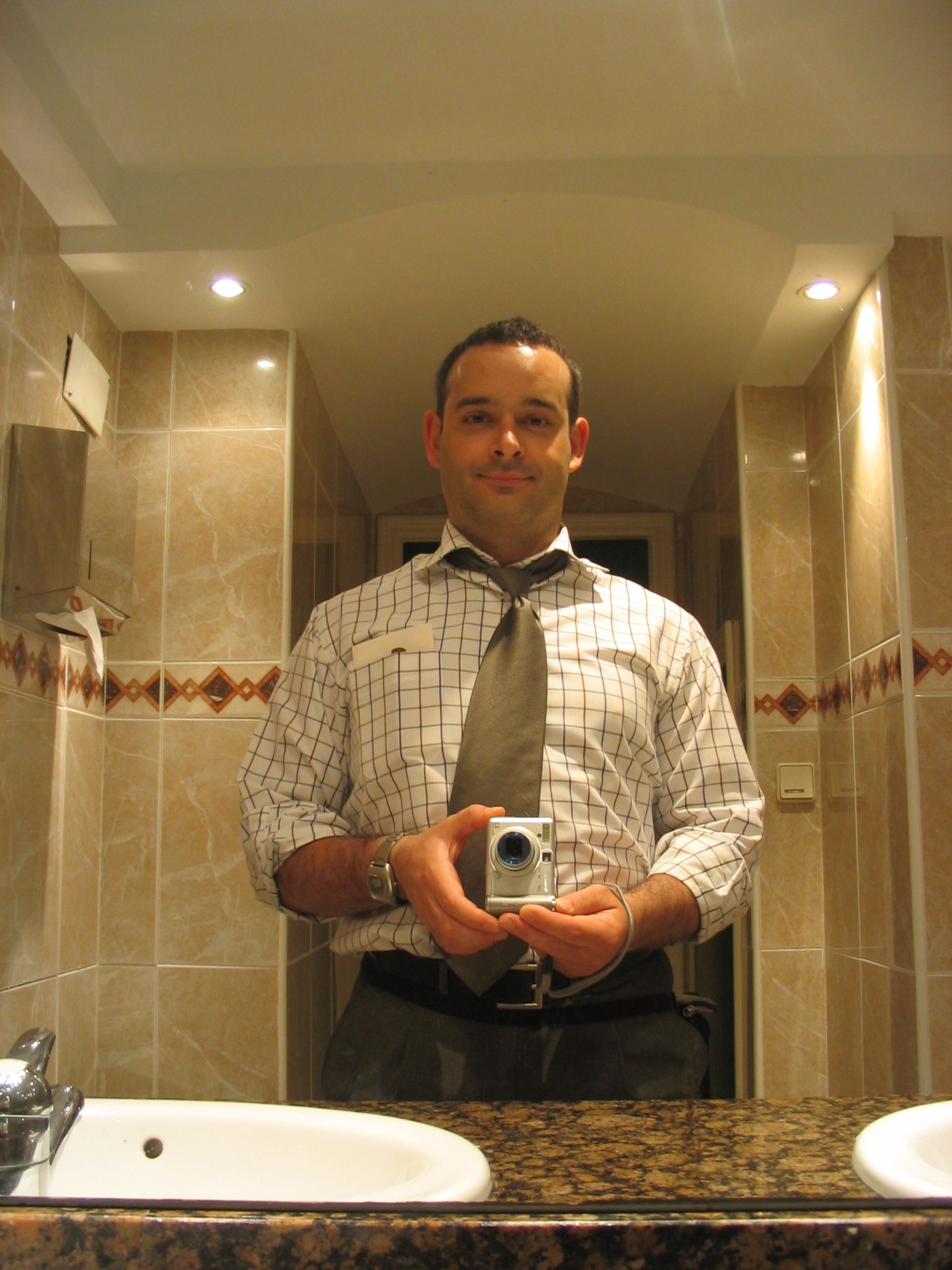 a man with a camera standing in front of a bathroom mirror