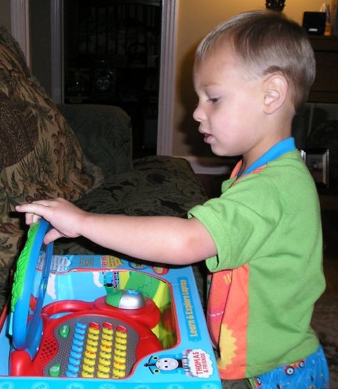 a child in green shirt playing with a toy