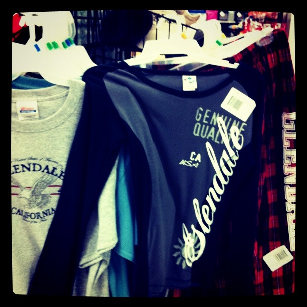 some shirts are hanging on a rack next to each other
