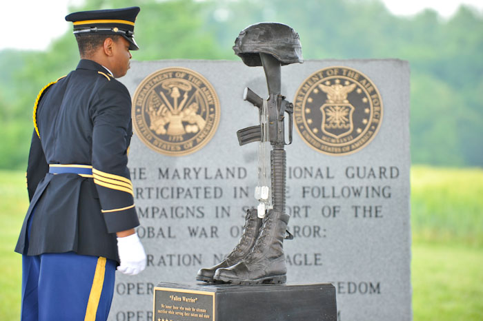 a navy man is next to a memorial display
