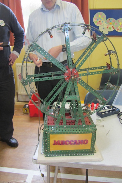 people standing around an assorted ferris wheel model