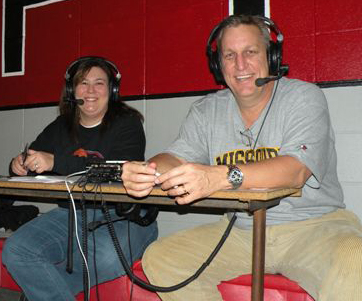 two people in a sports studio wearing headphones, with red walls