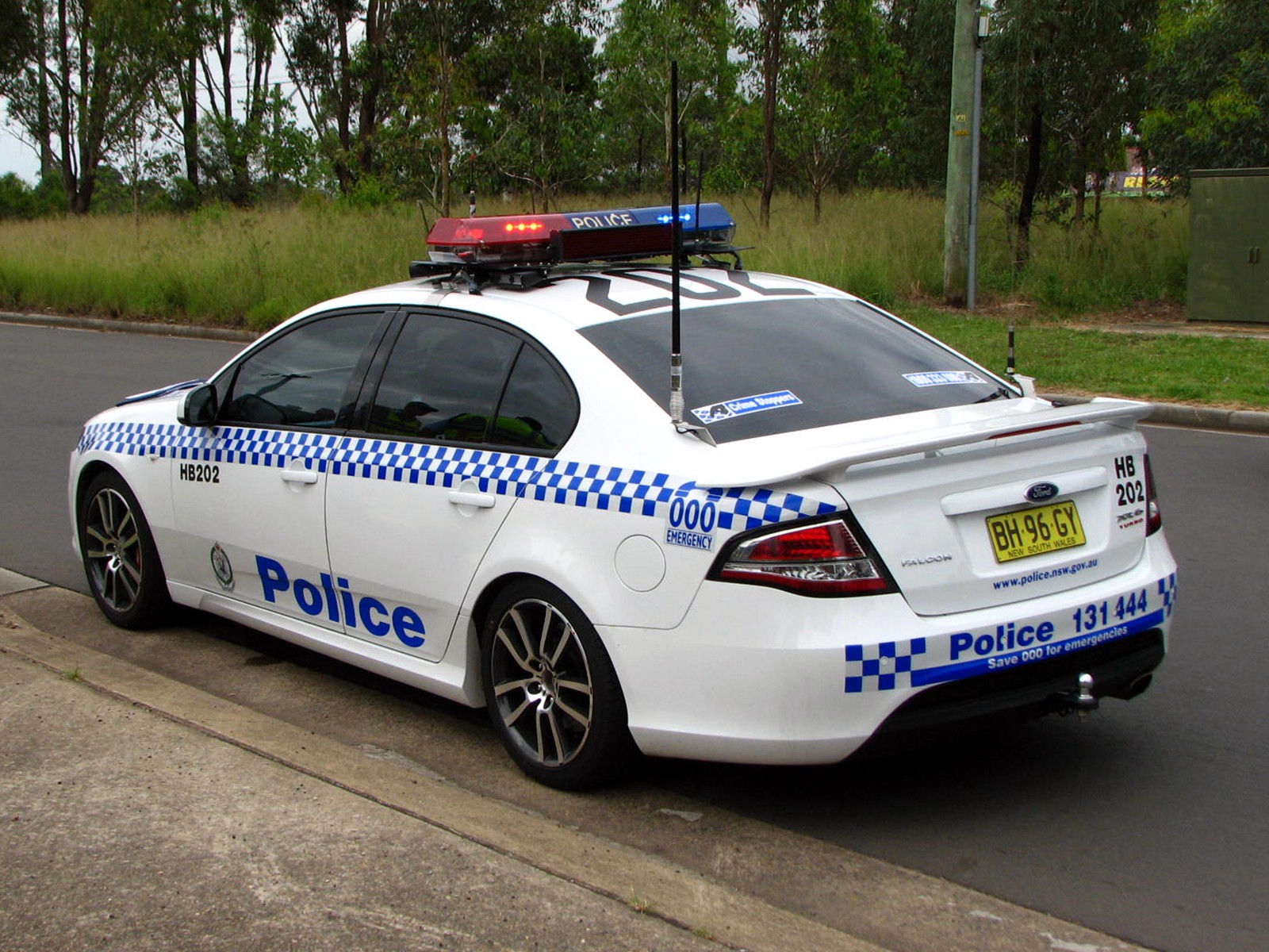 a police car with lights on in front of the road