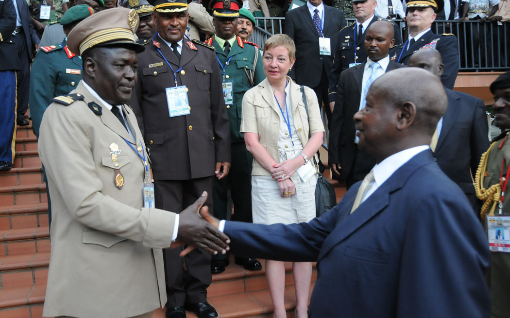 two men shaking hands in front of some military