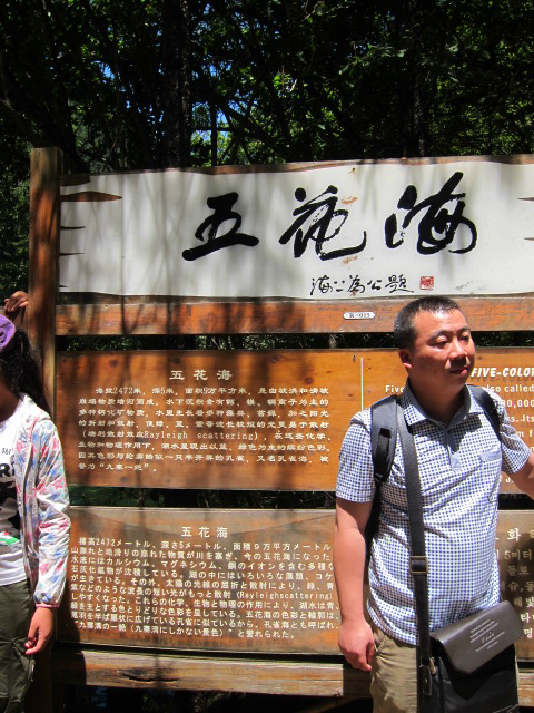 people in front of a sign at a park