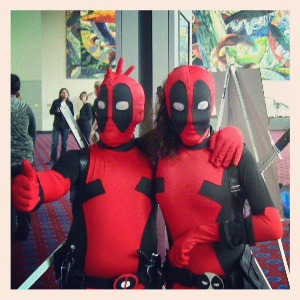 a couple of people wearing deadpool suits posing for a po
