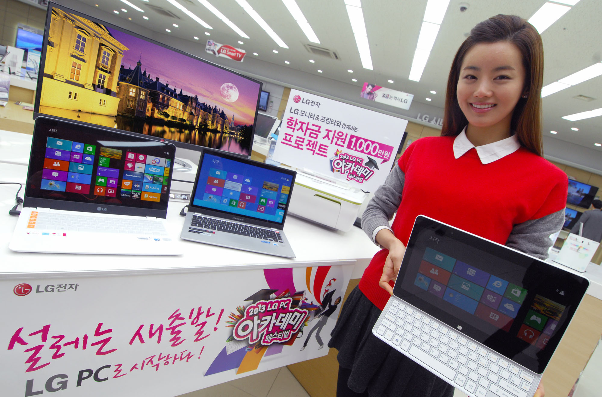 a woman standing in front of two open laptops
