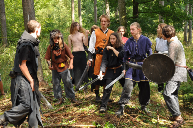 several people with large weapons and full body are looking at each other