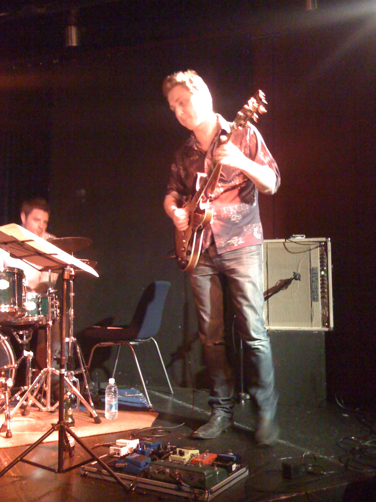 a man standing on a stage with musical instruments