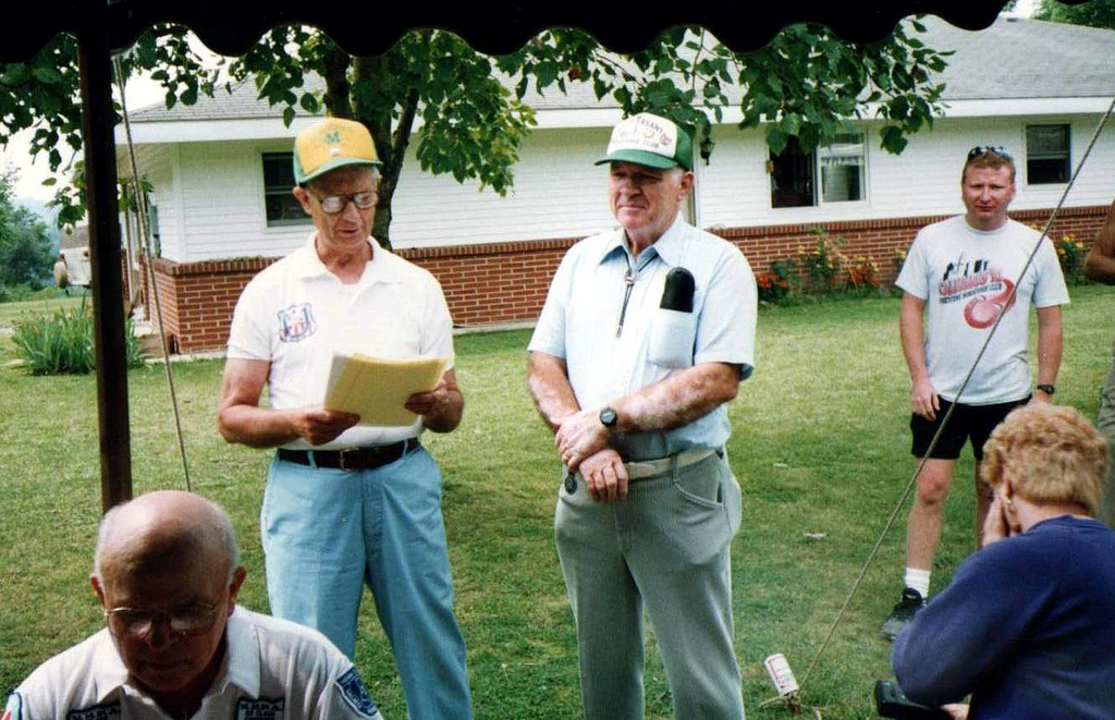 three men standing in front of a house