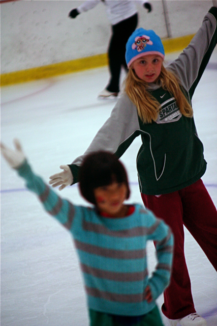 two people are skating on the ice rink together