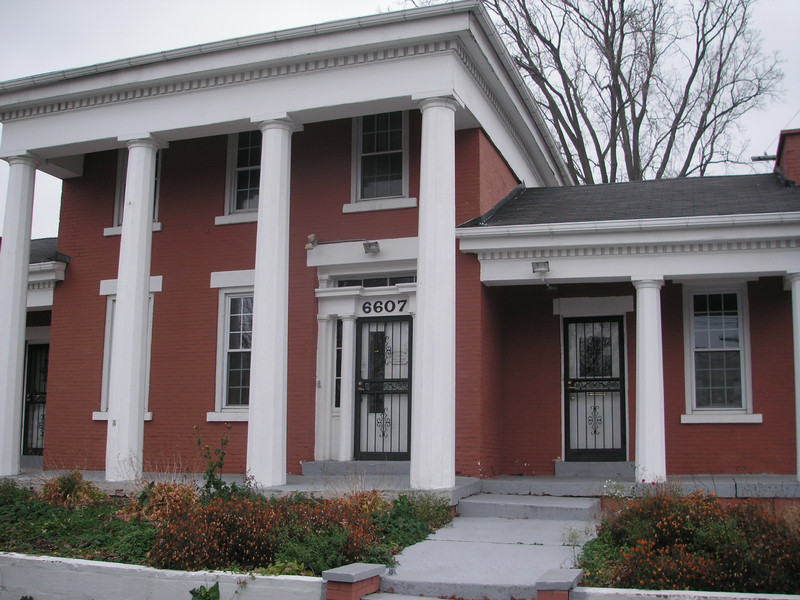 a red and white house with columns, porches and steps
