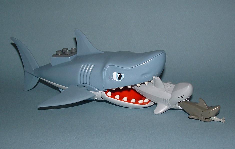 a plastic toy shark with a lego shark in front