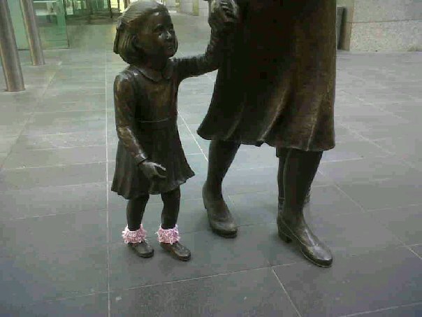 a statue with a little girl holding the hand of a large woman