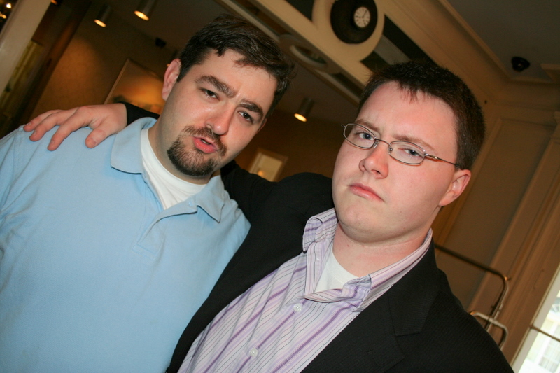 two men standing next to each other looking at the camera