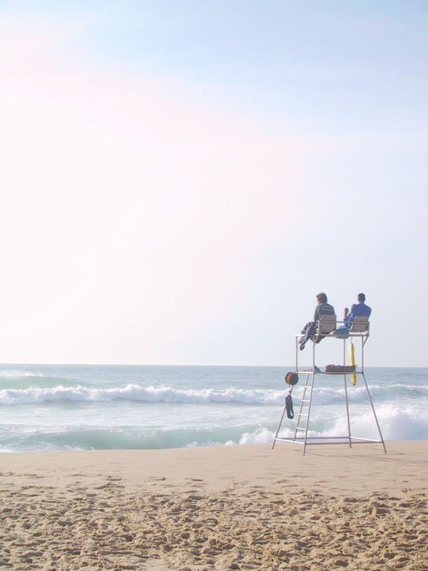 a group of people sitting in a life guard tower by the water