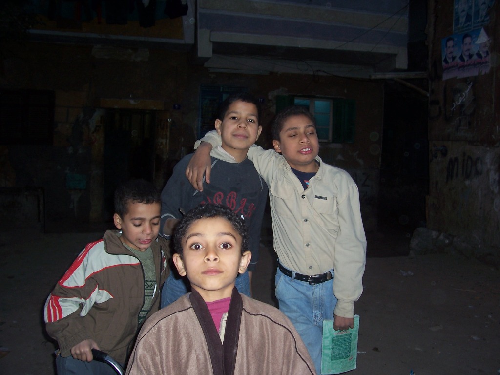 three boys standing near one another with a backpack