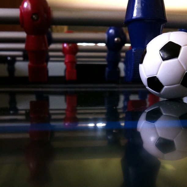 a soccer ball on top of a table next to three different colored figures