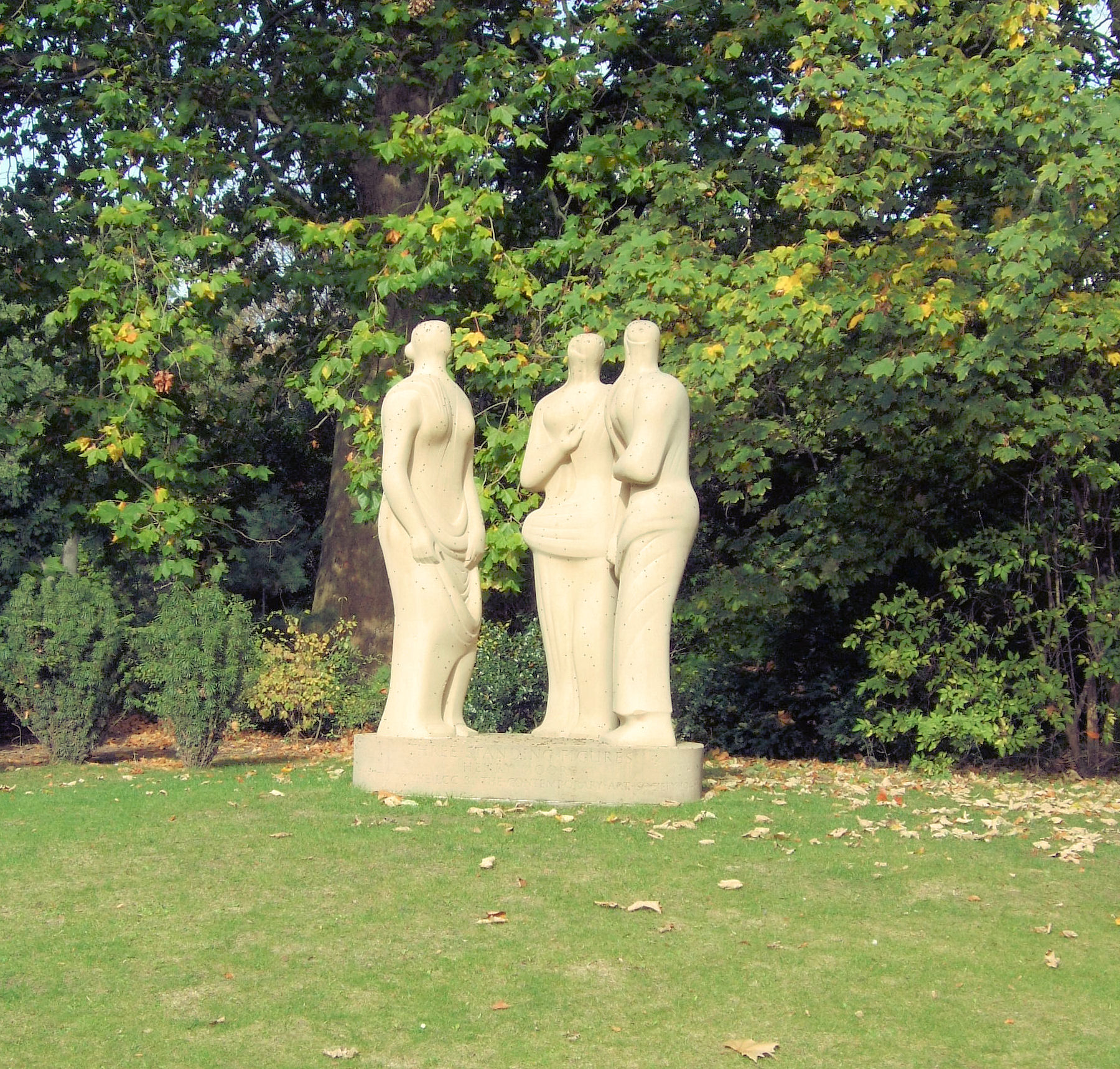 there are two statues in a garden near the trees