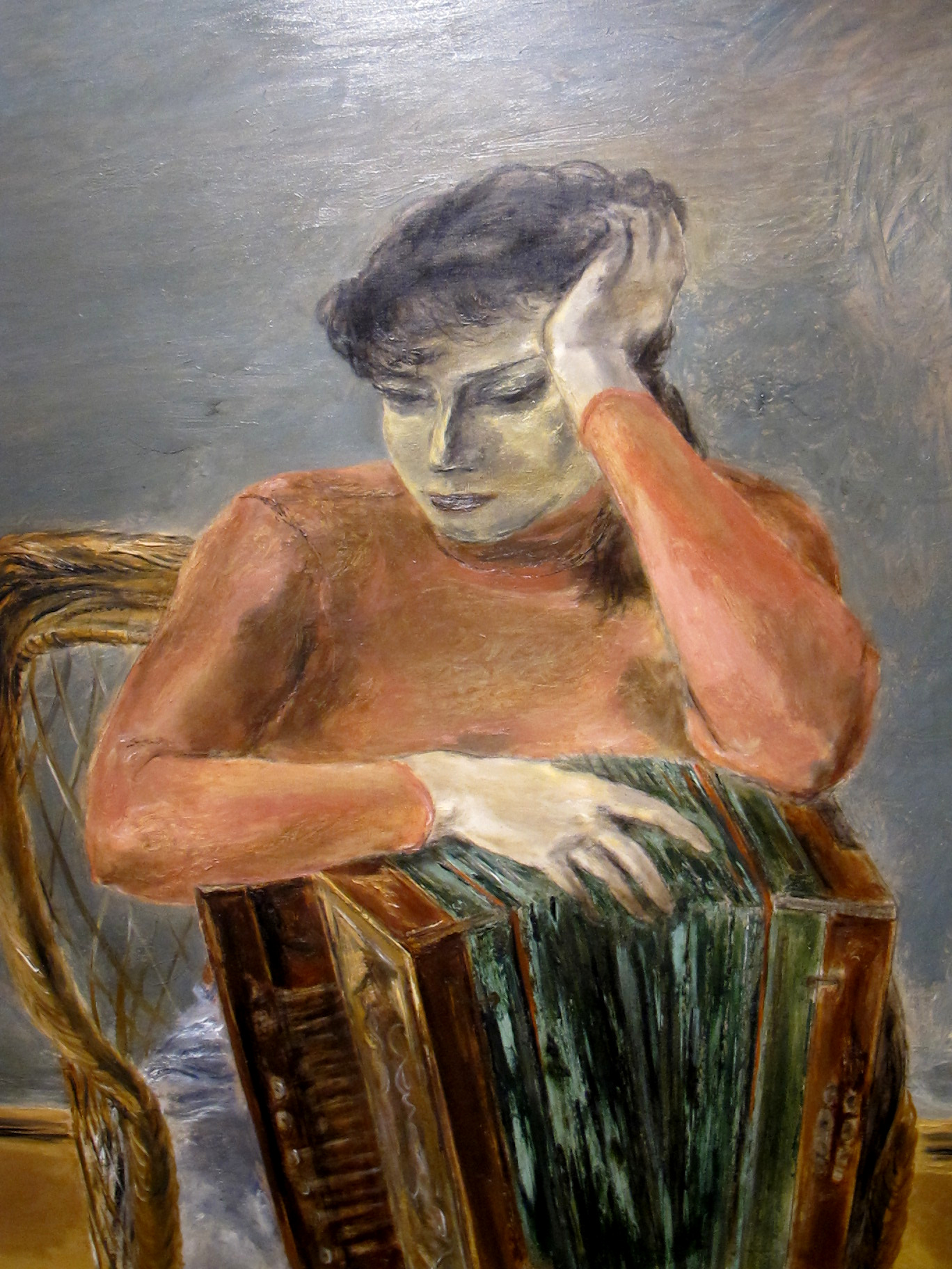 a man sits in front of a painting holding an accordian