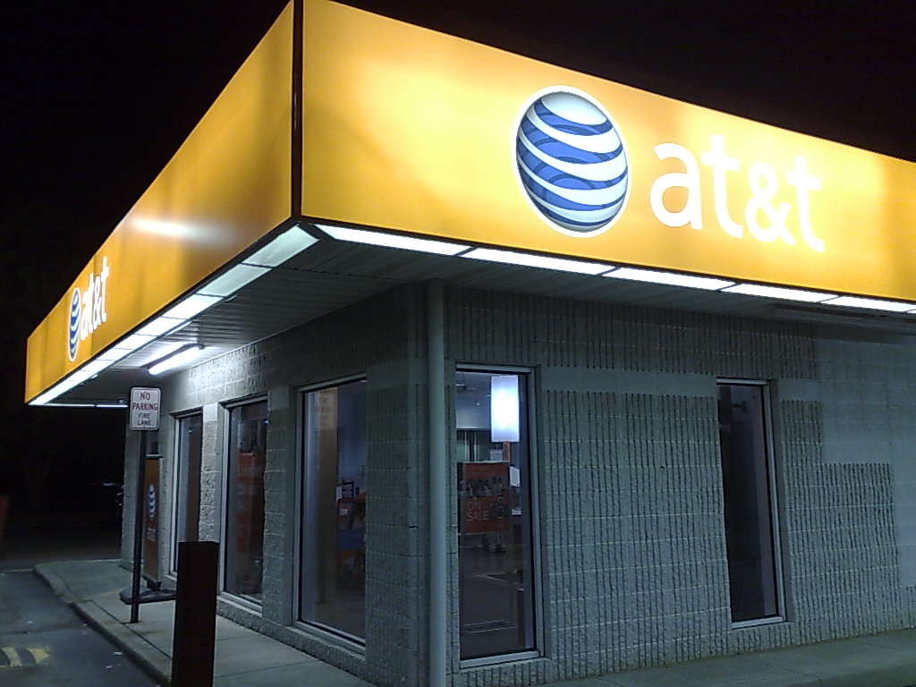 the front of a atm with its bright signage and lit up windows