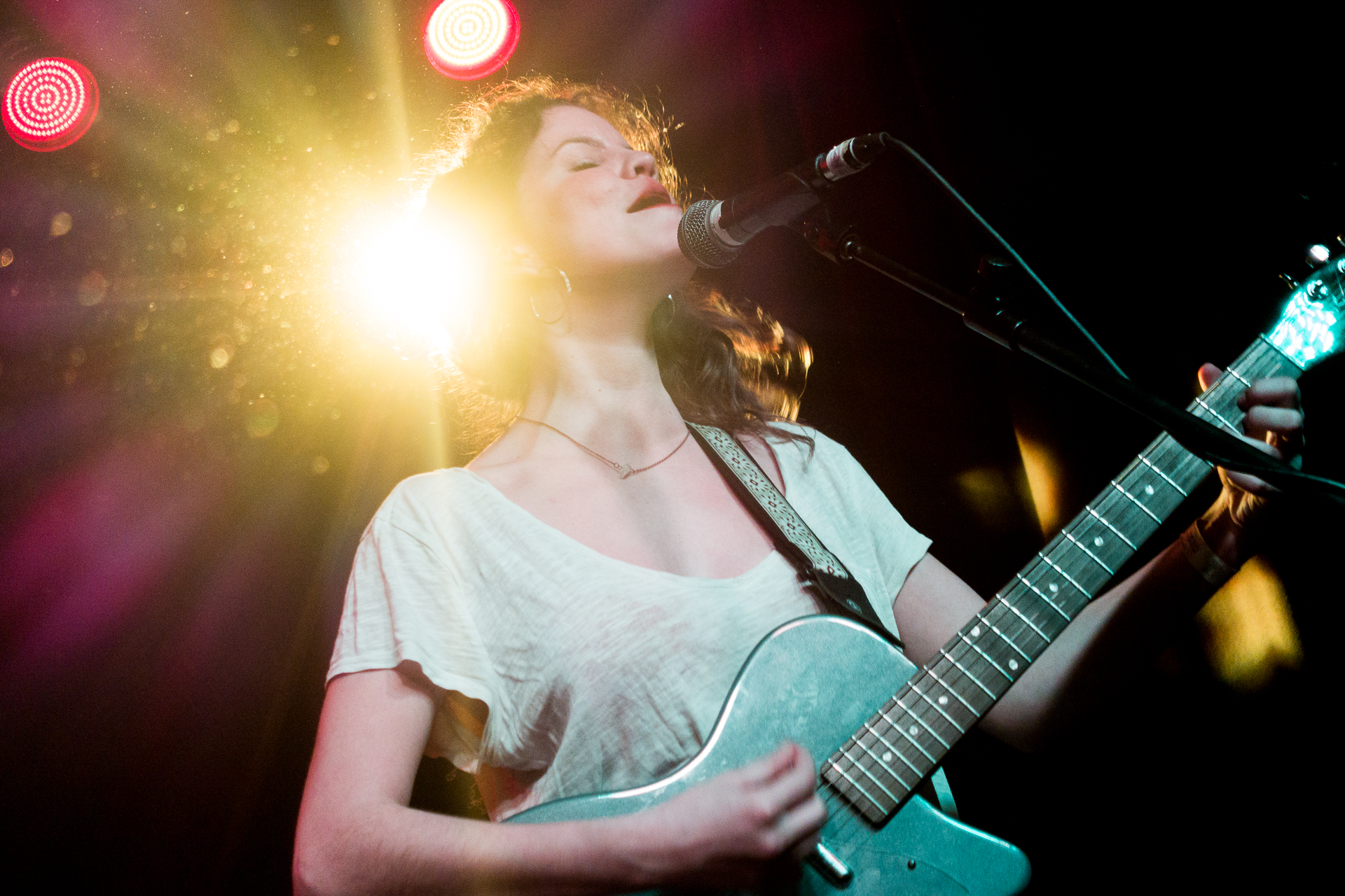 the woman is singing into the microphone while playing a guitar