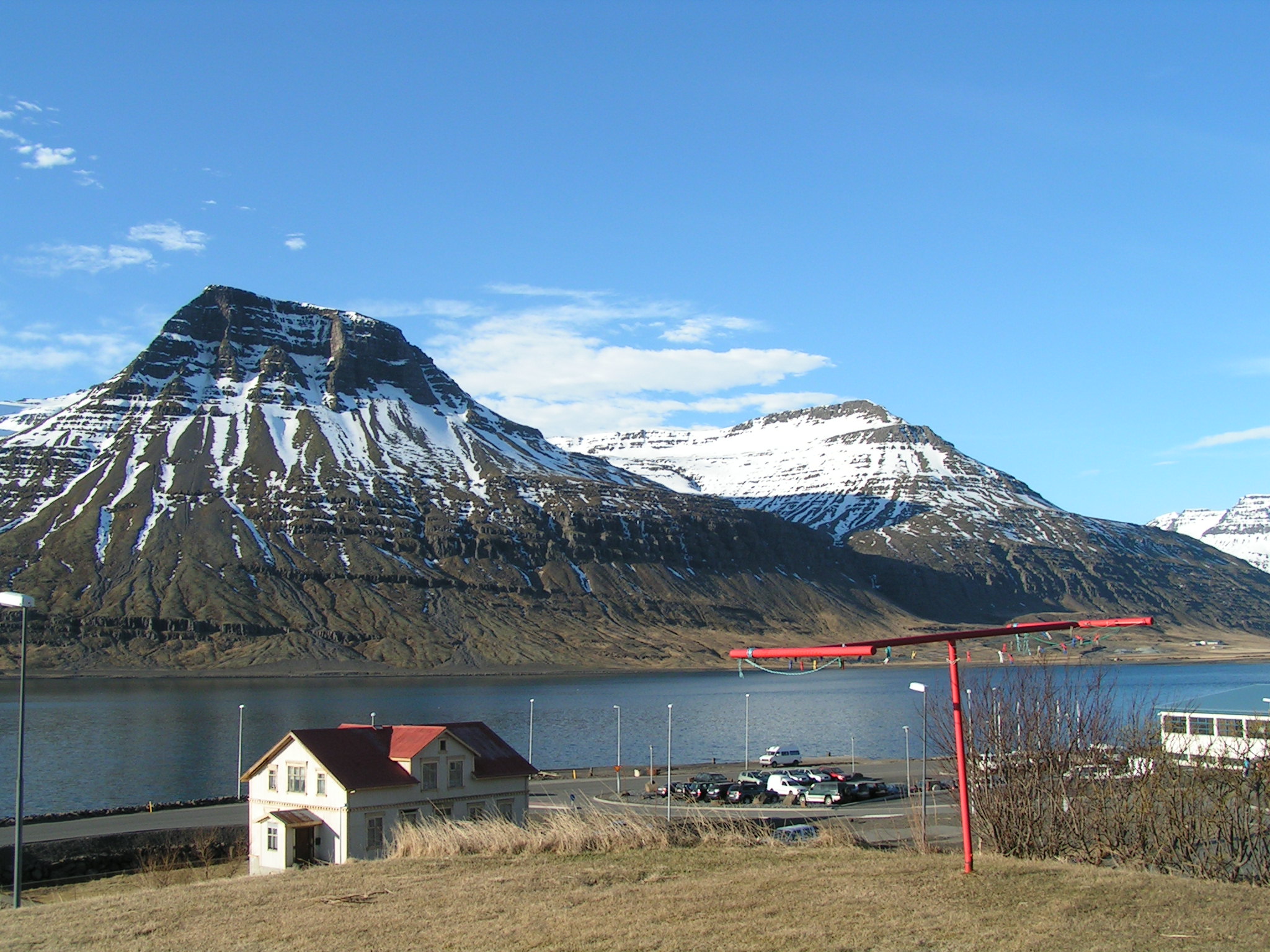 a big snowy mountain with some red building next to it