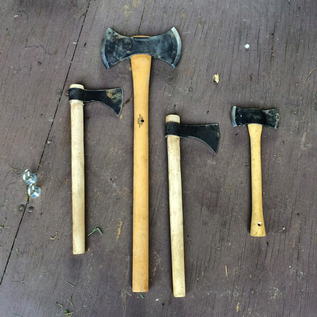 four hammers with a long handle laying on top of each other