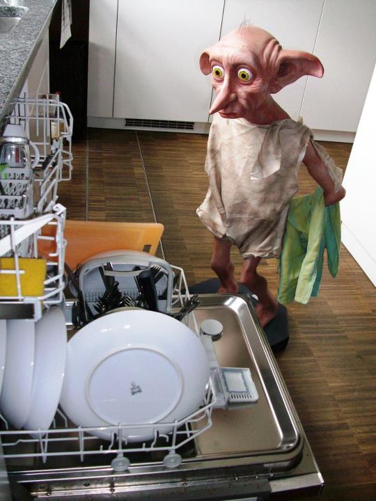 a strange looking person in a kitchen with dishwasher and dish racks full of clean dishes