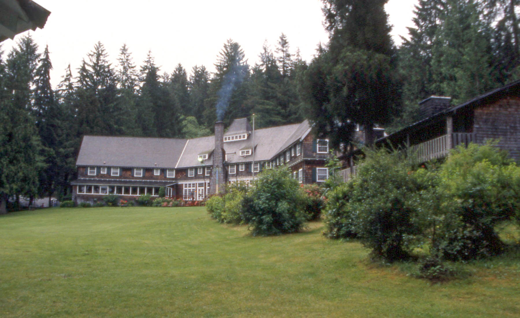 a large house on the side of a wooded hill