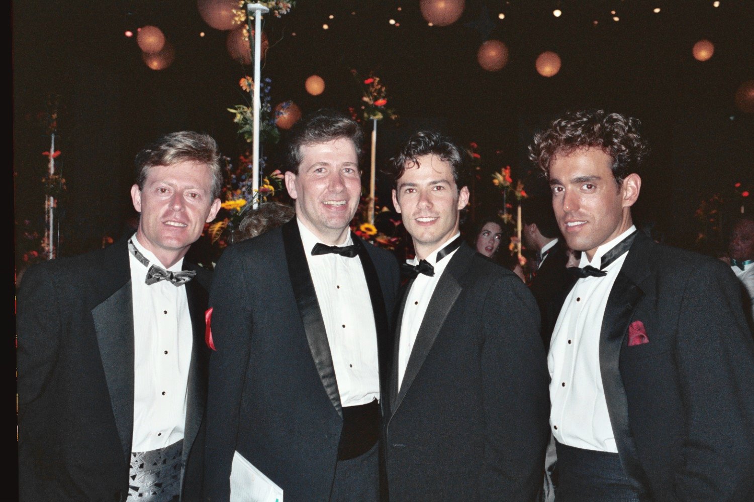 four men dressed in tuxedos are smiling